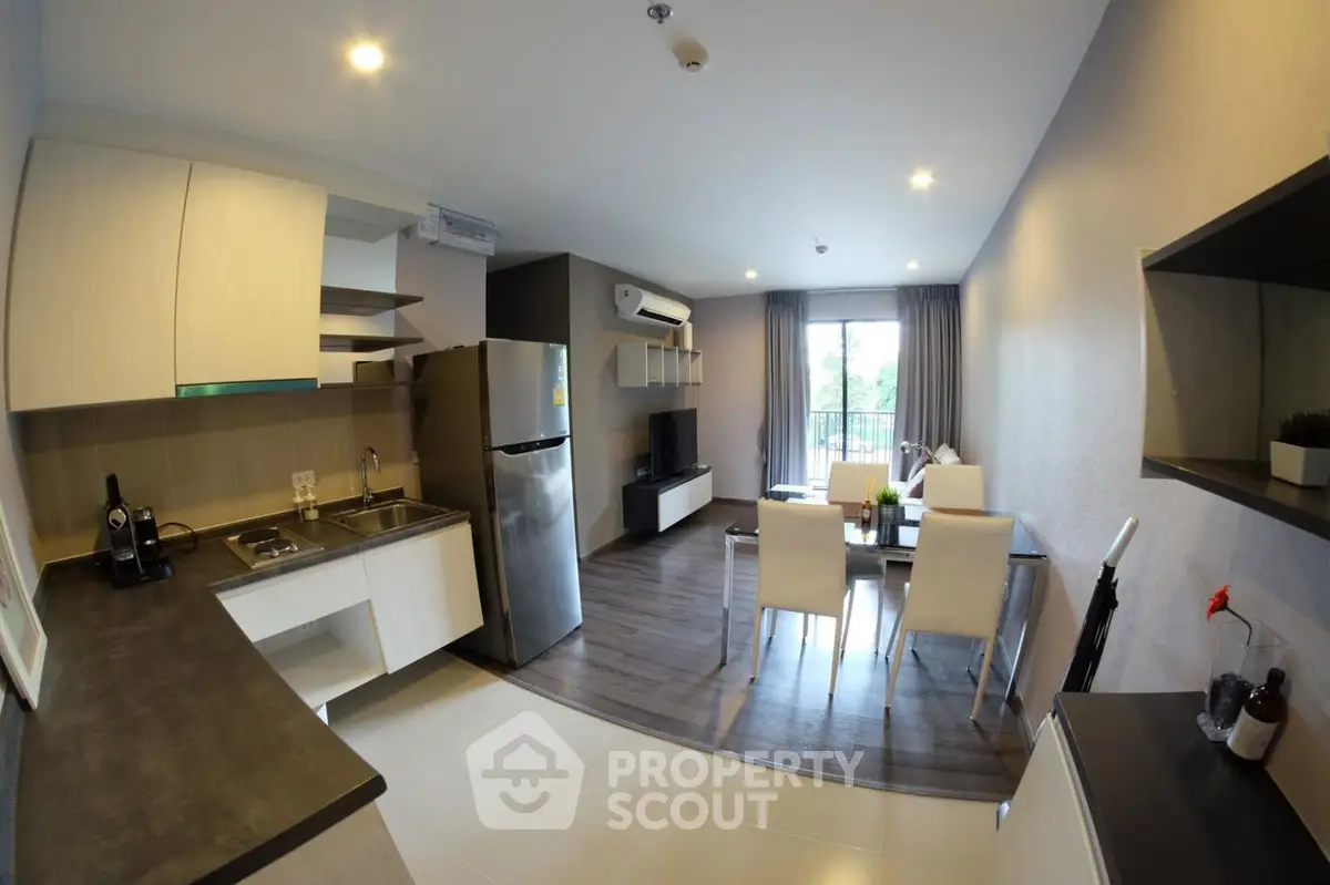 Modern open-layout kitchen and living room with sleek design and natural light.