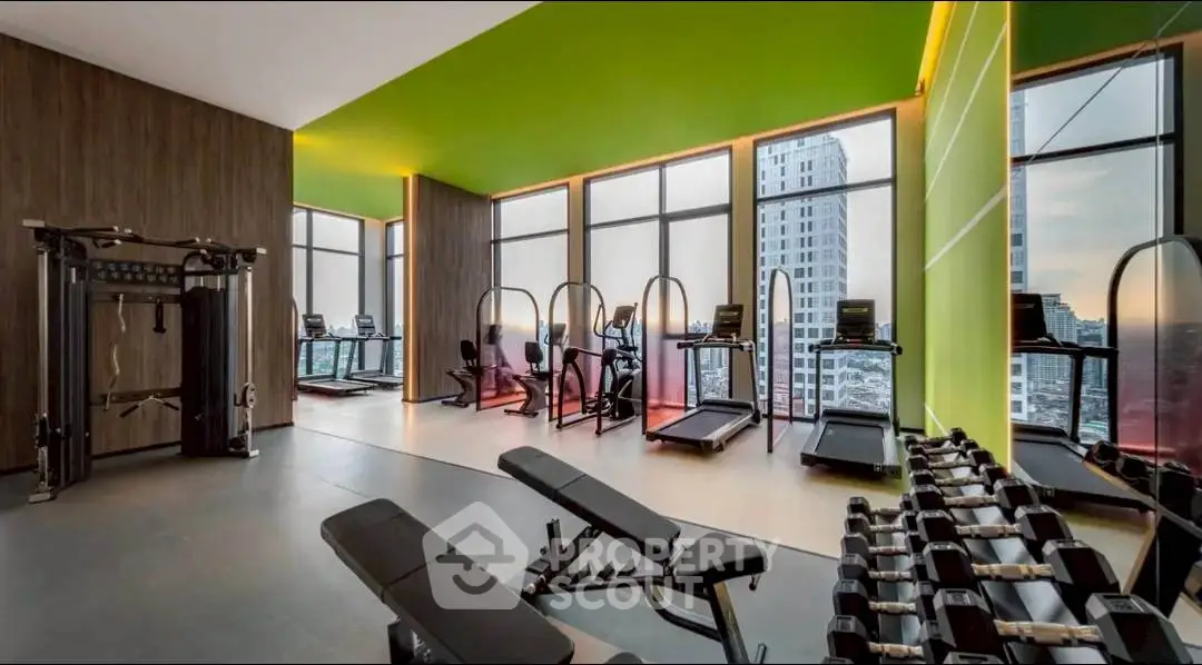 Modern gym with city view, featuring treadmills and weight benches in luxury high-rise.