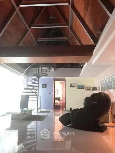 Spacious modern living room with high ceiling and spiral staircase in luxury home.