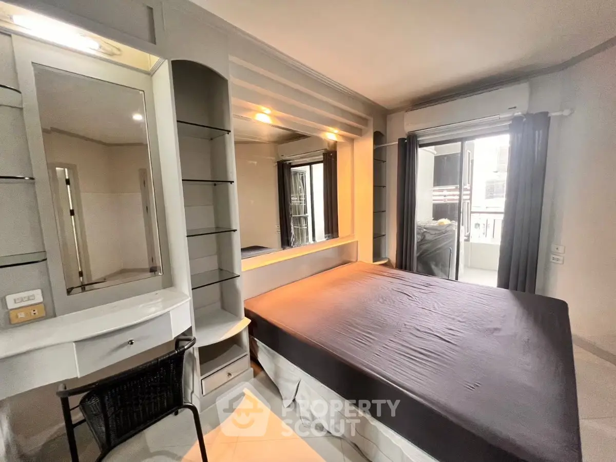 Modern bedroom with sleek design and balcony access in a stylish apartment.