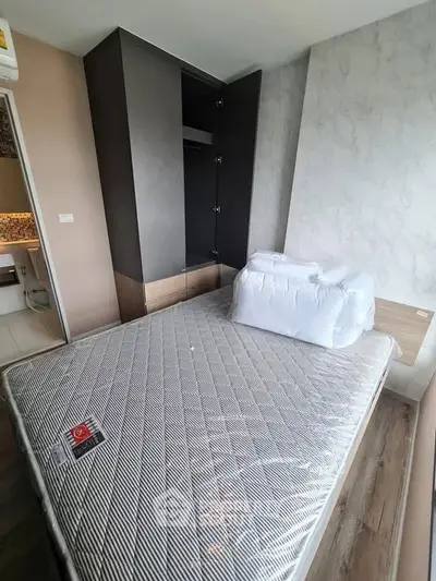 Modern bedroom with new mattress and built-in wardrobe in stylish apartment.