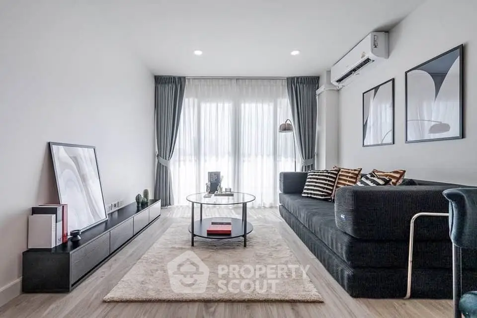 Modern living room with sleek furniture and large windows for natural light.