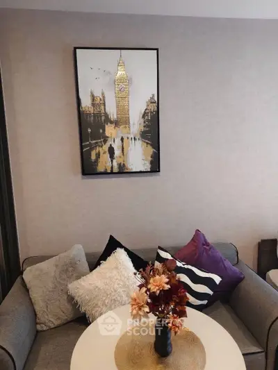 Cozy living room with stylish decor and artwork, featuring a comfortable sofa and elegant floral centerpiece.