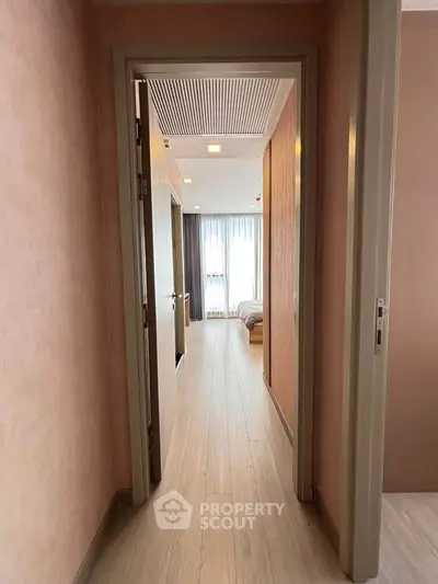 Bright hallway leading to a cozy bedroom with natural light and modern decor.