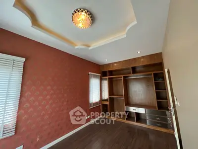 Spacious room with elegant ceiling light and built-in wooden storage