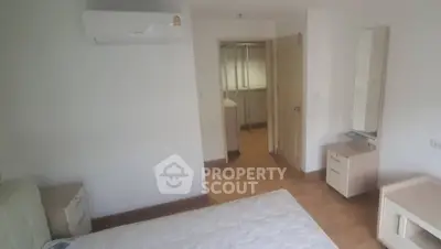 Spacious bedroom with air conditioning and wooden flooring, ideal for comfort and relaxation.