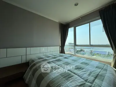 Spacious bedroom with large window offering stunning city and river views