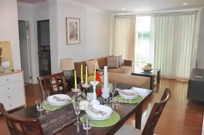 Spacious living room with elegant dining area and cozy seating, featuring natural light and stylish decor.