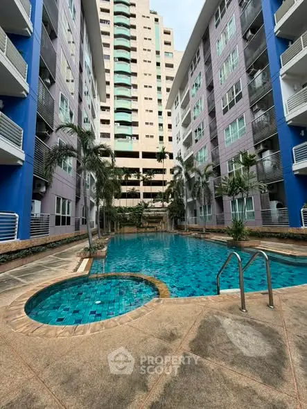 Stunning residential pool area with modern high-rise buildings and lush palm trees.