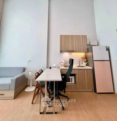 Modern studio apartment with compact kitchen and workspace, featuring sleek wooden cabinetry and minimalist design.