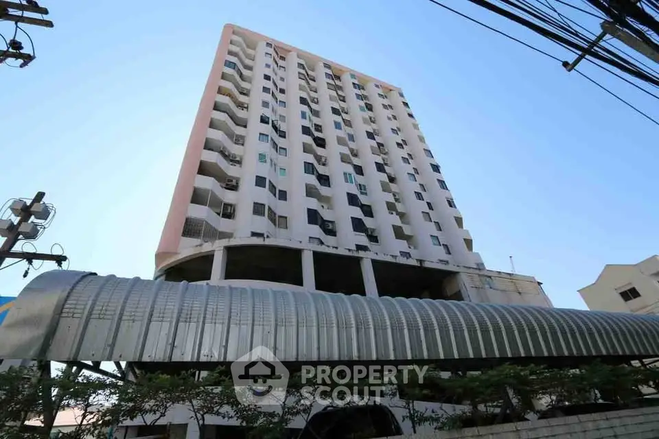 Modern high-rise building with unique architectural design and spacious balconies.
