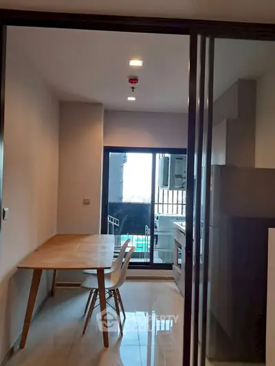 Modern kitchen with open layout and sleek dining area in contemporary apartment.