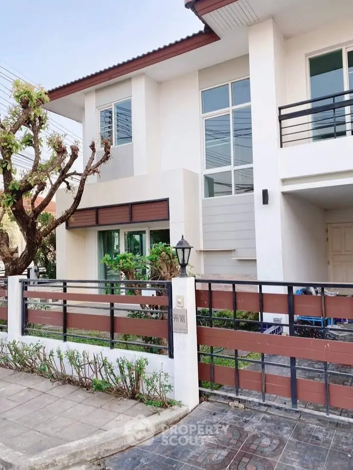 Modern two-story house with large windows and a stylish front yard.