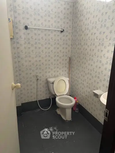 Compact bathroom with tiled walls and basic fixtures, ideal for small spaces.