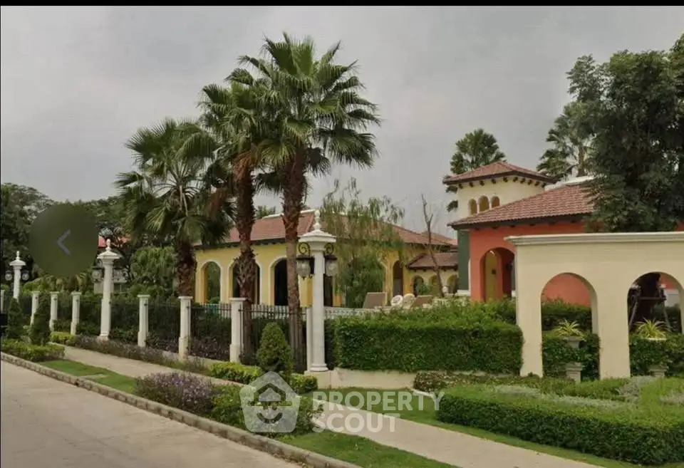 Luxurious Mediterranean-style villa with lush landscaping and palm trees