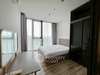 Modern bedroom with large window and stylish furnishings