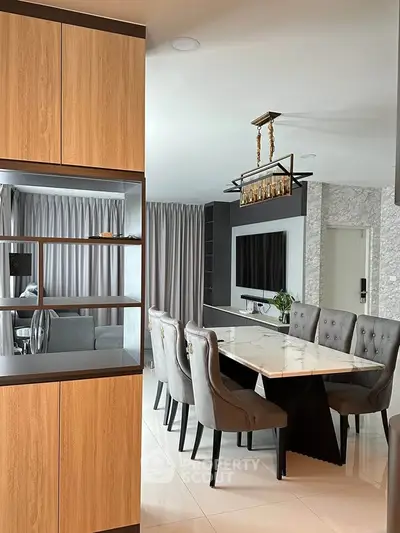 Elegant dining area with marble table and plush chairs in modern open-plan living space.