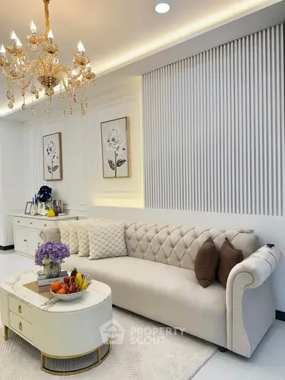 Luxurious living room with elegant chandelier and plush sofa in modern apartment.
