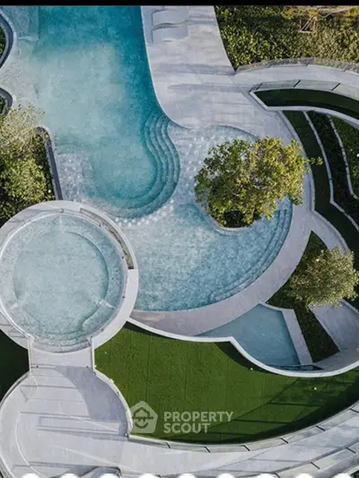 Luxurious aerial view of modern pool with lush landscaping and elegant design.