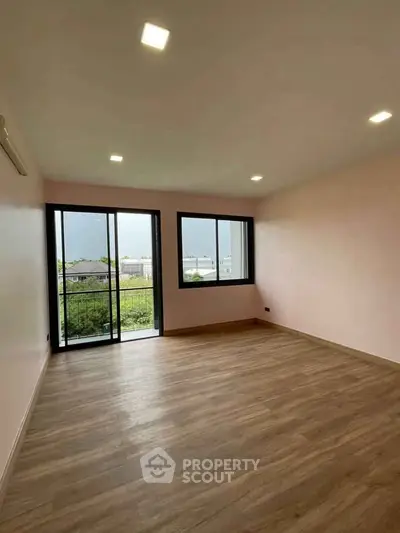 Spacious empty room with large windows and balcony access, perfect for customization.