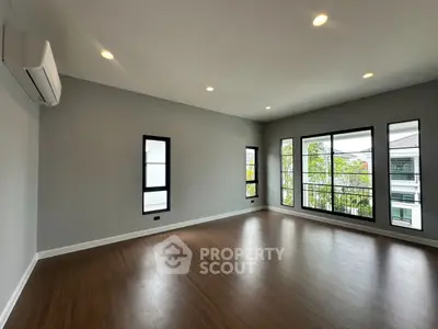 Spacious empty living room with large windows and wooden flooring