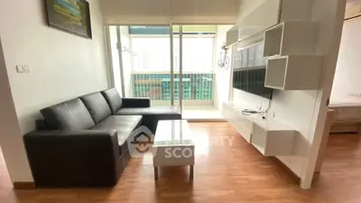 Modern living room with sleek black sofa and wall-mounted TV unit, featuring a balcony view.