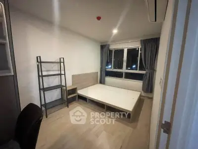 Spacious bedroom with modern minimalist design and large window for natural light.