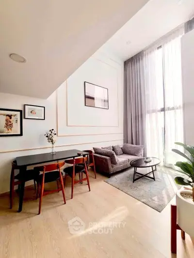 Modern living room with high ceilings, elegant decor, and abundant natural light in a stylish apartment.