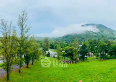 Scenic view of lush green landscape with mountains and houses, perfect for serene living.