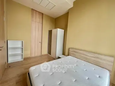 Modern minimalist bedroom with wooden flooring and sleek furniture
