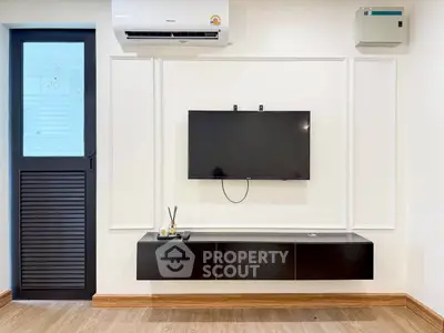Modern living room with wall-mounted TV and sleek black console