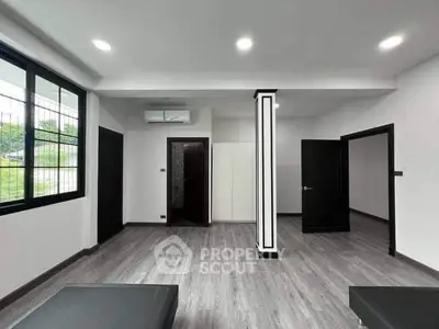 Spacious modern living room with sleek flooring and ample natural light.