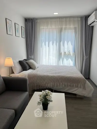 Modern bedroom with cozy decor and natural light, featuring a comfortable bed and stylish furnishings.