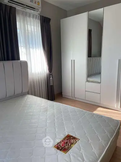 Bright bedroom with large window, mirrored wardrobe, and comfortable bed.