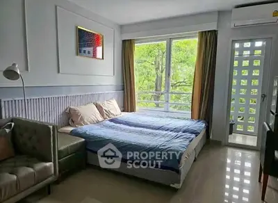 Bright bedroom with large window and modern decor in a cozy apartment.