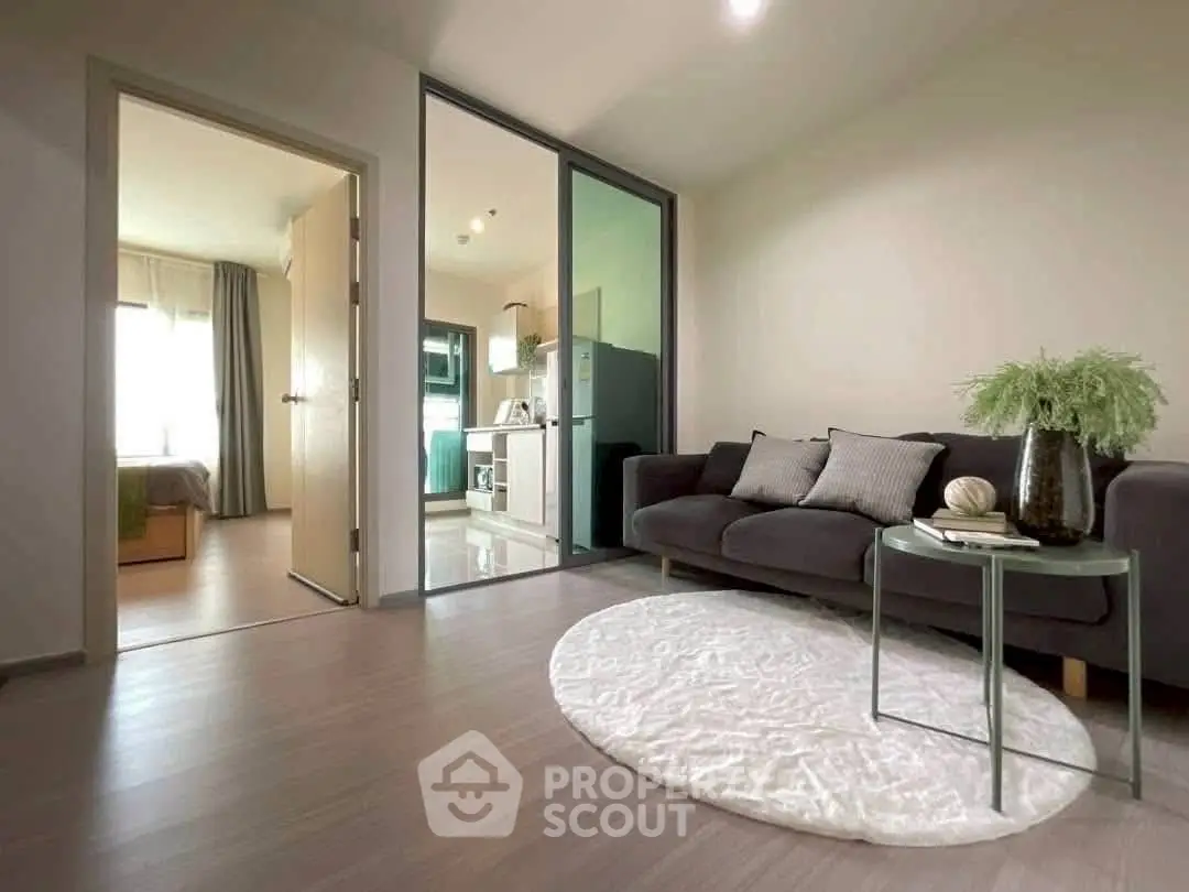 Modern living room with sleek design, cozy sofa, and open view to kitchen and bedroom.