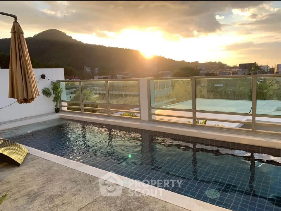 Stunning rooftop pool with mountain view at sunset, perfect for relaxation and luxury living.