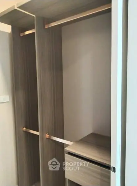 Spacious walk-in closet with modern wooden finish and ample storage space.