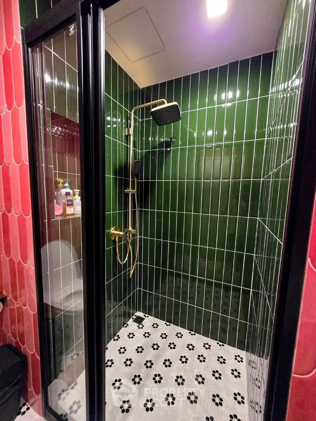 Stylish modern bathroom with black and green tiles and elegant shower fixtures.