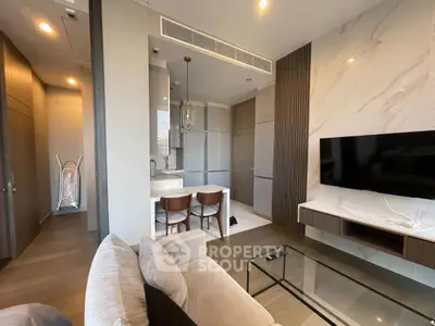 Modern living room with open kitchen, sleek design, and stylish furniture in a contemporary apartment.