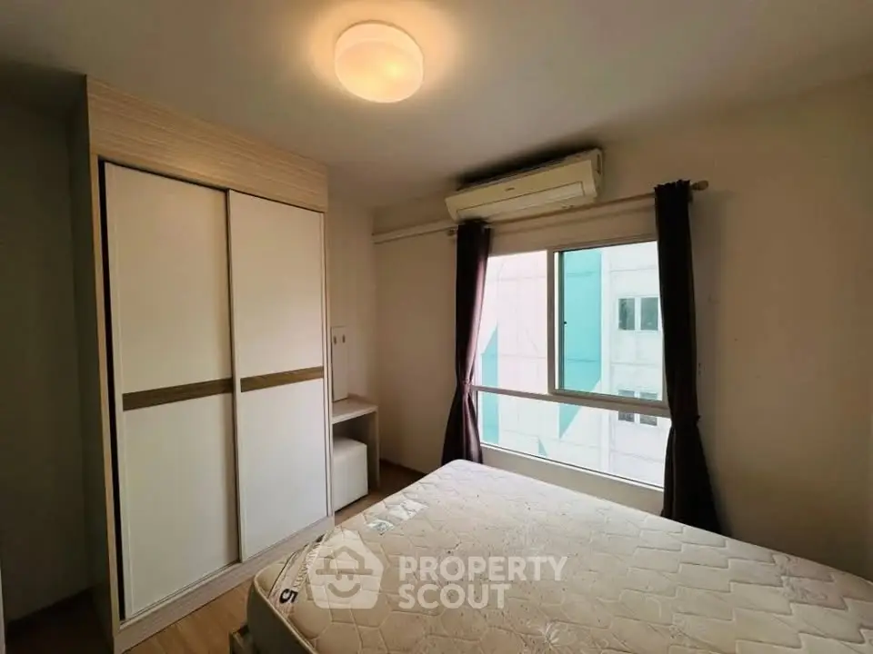 Cozy bedroom with large window and built-in wardrobe, perfect for natural light lovers.