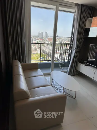 Modern living room with city view from balcony, featuring sleek furniture and large windows.