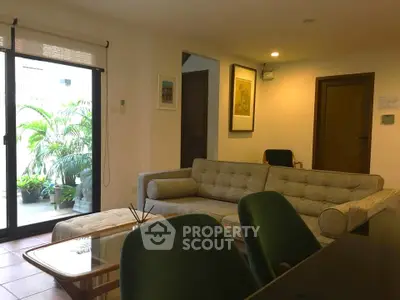 Chic living room with modern sofa and lush balcony view, perfect for relaxation and entertaining.