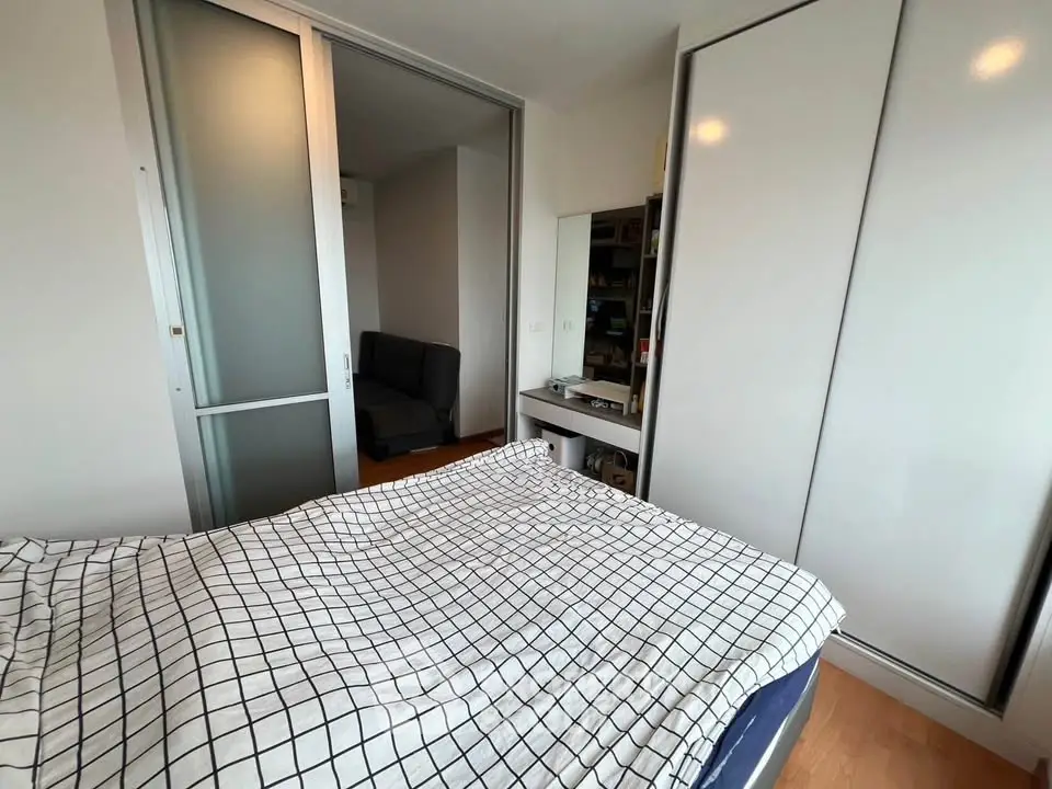 Modern bedroom with sliding closet doors and cozy bed in stylish apartment.