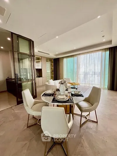 Luxurious dining area with elegant table setting and floor-to-ceiling windows in modern apartment.