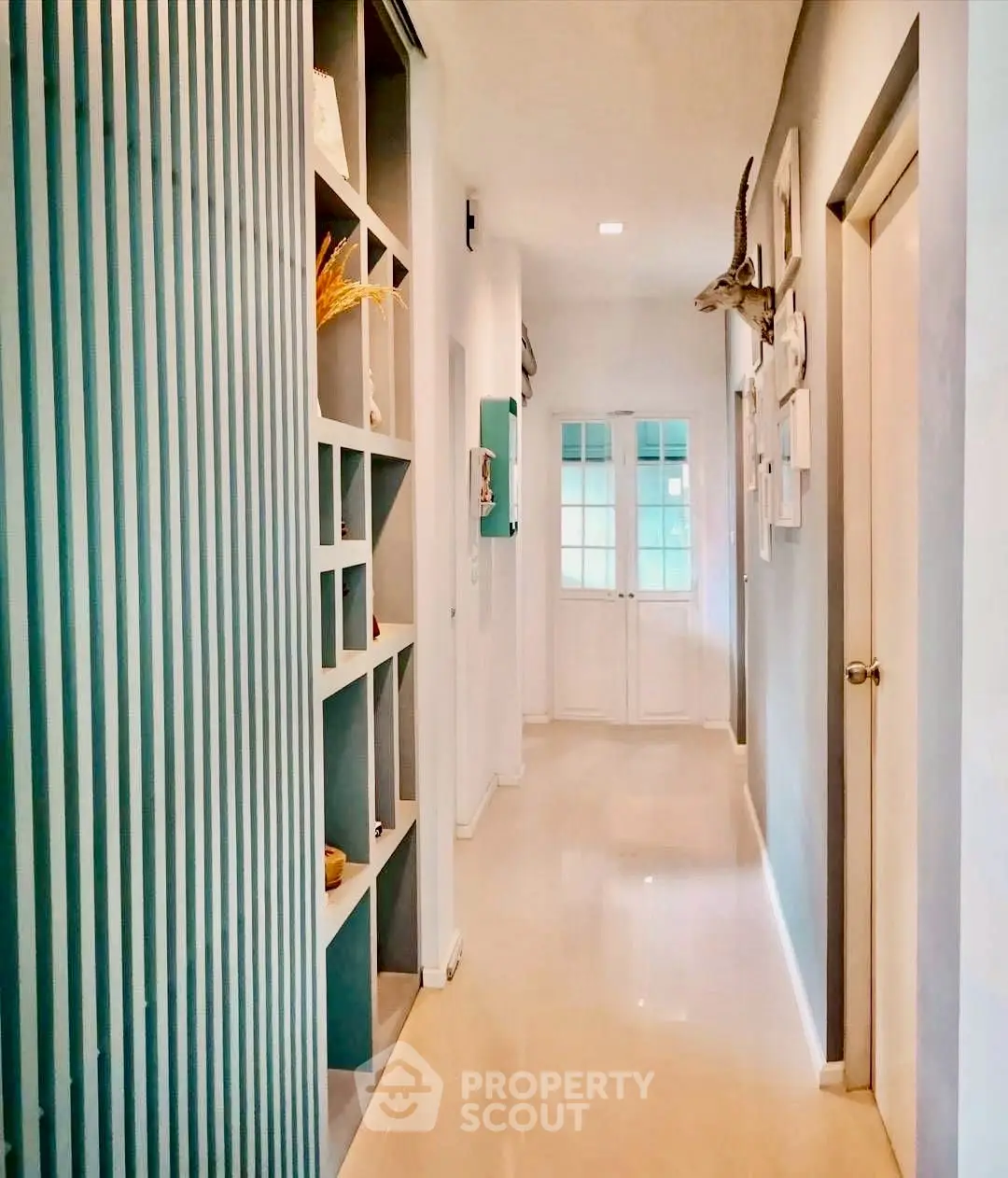 Stylish hallway with modern decor and elegant lighting leading to a bright doorway.