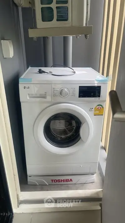 Modern washing machine in compact laundry space with sleek design