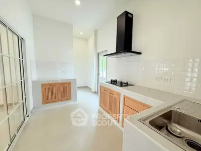 Modern kitchen with sleek design, featuring gas stove and ample natural light.
