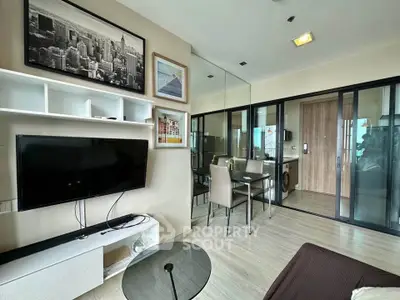 Modern living room with glass partition, stylish decor, and dining area in a chic apartment.