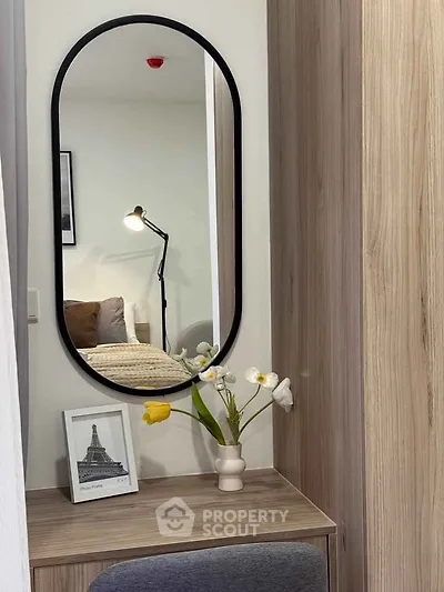 Stylish bedroom corner with mirror, lamp, and floral decor